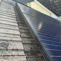 Solar panel protection in Barnstaple, Devon Solar panels installed on a sloped roof beside textured tiles.